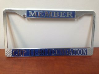 Chp 11 - 99 Foundation License Plate Frame.  Blue Lettering.  Made Of Metal.
