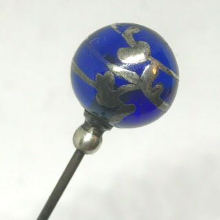Antique Hat Pin Striking Cobalt Blue Sphere With Wispy Silver Overlay.