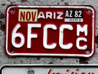 White On Red Arizona Motorcycle License Plate With A 1982 Sticker