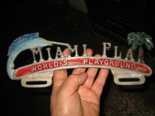 RARE VINTAGE LICENSE PLATE TOPPER CAST METAL MIAMI FLORIDA.  WORLD ' S PLAYGROUND 4