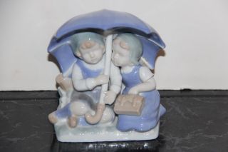 Vintage Porcelain Figurine Of A Boy And Girl Under A Umbrella
