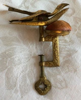 Early Antique Sewing Bird,  Brass,  Clamps On Table & Holds Fabric,  With Pin Cushi