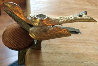 Early Antique sewing bird,  brass,  clamps on table & holds fabric,  with pin cushi 3