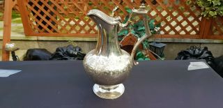 An Antique Victorian Silver Plated Water Jug With Engraved Patterns.