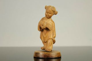 A Chinese carved wood figure of a child with a book mark to base 20thc 2